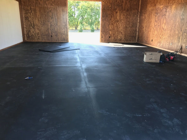Hammerlock vulcanized interlocking rubber tiles being installed in an athletic weight room facility
