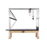 The Echo Kodiak Echo Pilates Cadillac Reformer Vintage features a solid oak frame with metal bars, springs, and straps.