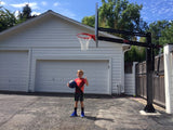 Child playing on the First Team Force Pro adjustable basketball hoop lowered for youth play