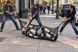 Three use Kodiak Sports’ Robot Capture and Containment Netting on a sidewalk; one destroys robot with a bat.